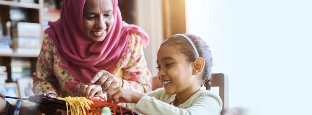 a picture of Muslim hijabi mother and daughter doing school craft work - It's for a blog post on the subject kids calendar in Ramadan