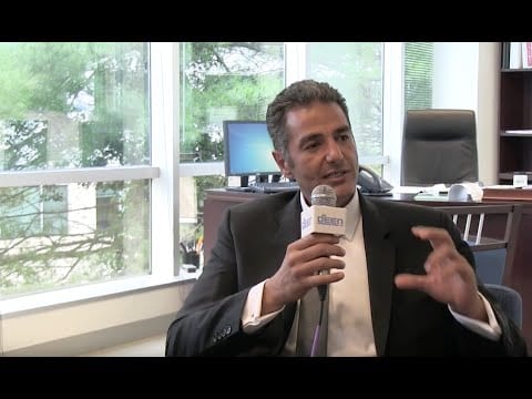 man sitting down with microphone speaking